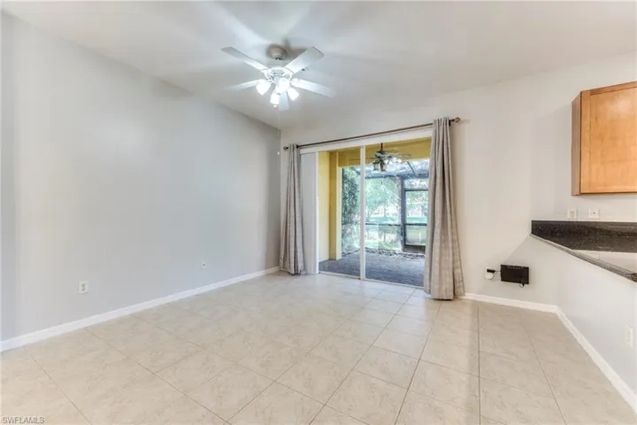 Empty room with a ceiling fan and light tile patterned floors