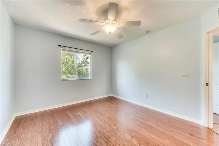 Bedroom with wood finished floors, a ceiling fan, and a smoke detector