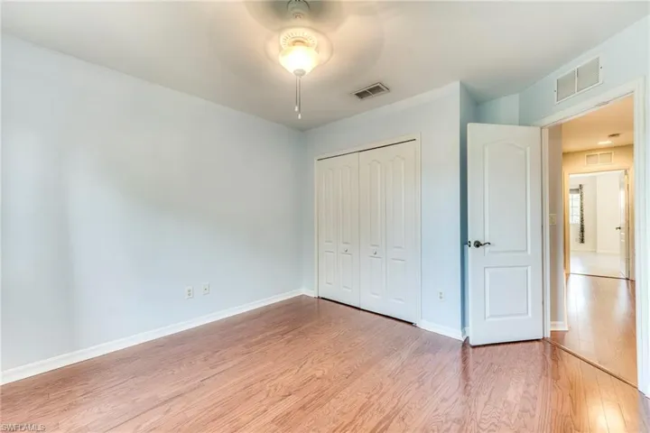 Bedroom featuring light wood-style flooring, a closet, and a ceiling fan