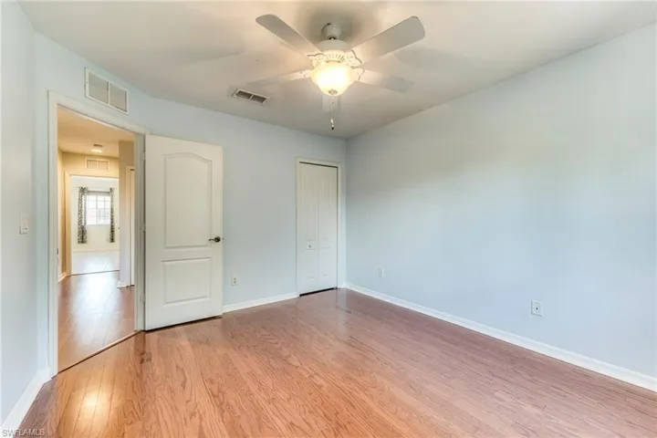 Bedroom with light wood finished floors, a closet, and a ceiling fan
