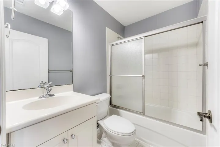 Bathroom featuring vanity and combined bath / shower with glass door