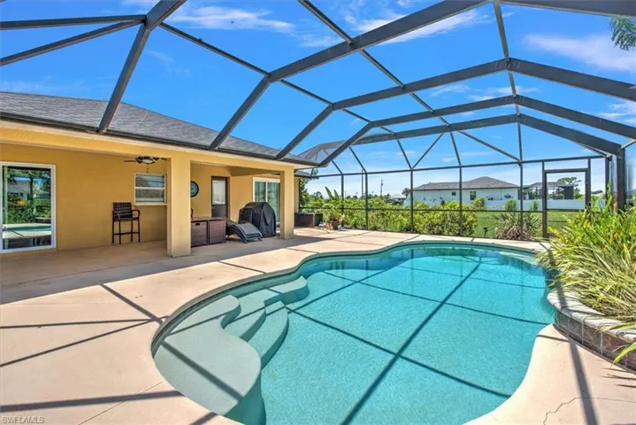 View of swimming pool featuring ceiling fan, glass enclosure, and a patio
