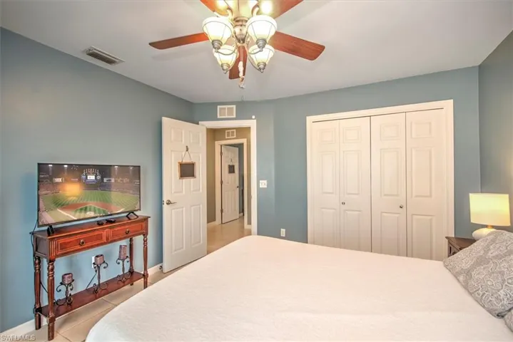 Bedroom with tile flooring, a closet, and ceiling fan