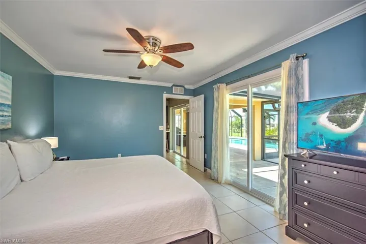Bedroom featuring ceiling fan, crown molding, light tile flooring, and access to outside