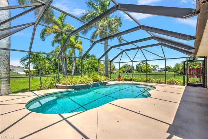 View of pool with a patio and glass enclosure
