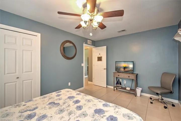 Bedroom featuring ceiling fan, a closet, and light tile floors