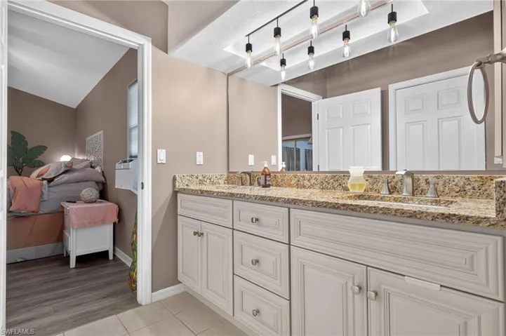 Double vanity with granite-style countertop, dual undermount sinks, and brushed nickel fixtures