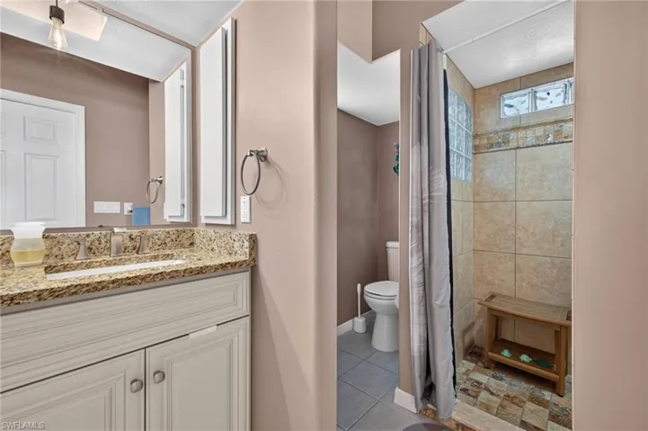 Vanity with granite countertop, integrated sink, and undermount cabinetry