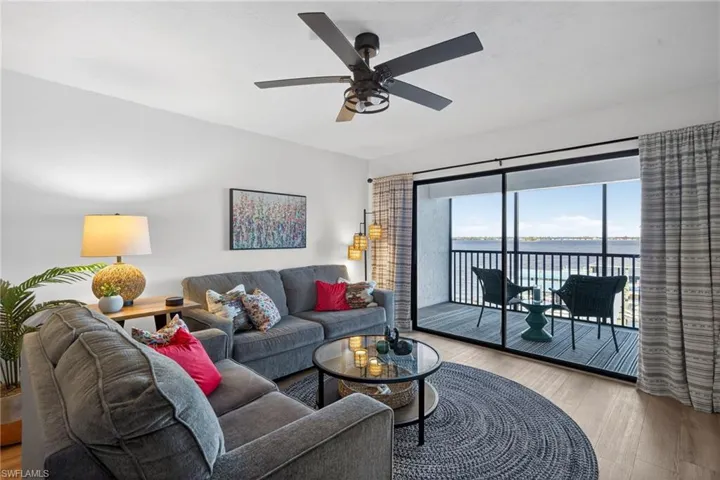 Living room featuring a water view, wood finished floors, and a ceiling fan