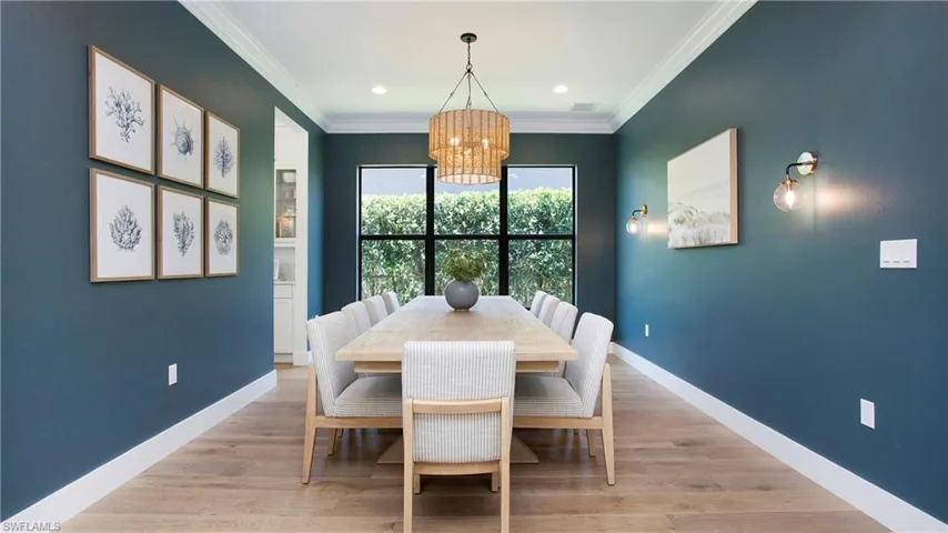 Dining room with a chandelier, crown molding, baseboards, light wood finished floors, and recessed lighting