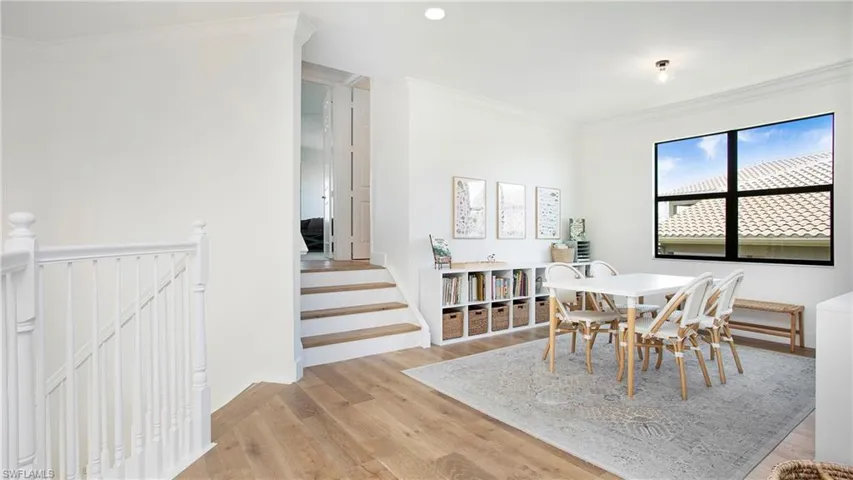 Dining area featuring light wood-type flooring and crown molding