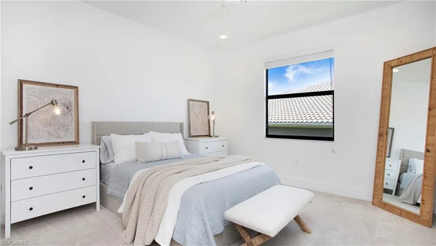 Bedroom with light colored carpet, a ceiling fan, and baseboards