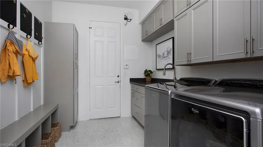 Washroom featuring cabinet space and washing machine and clothes dryer