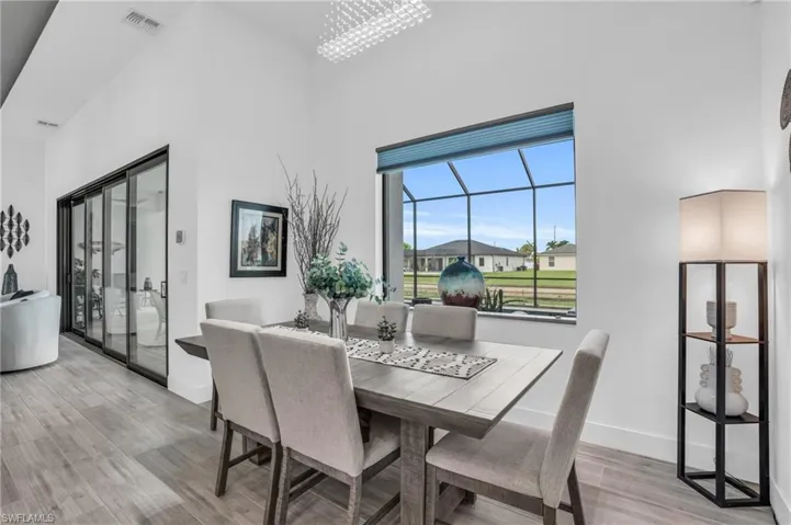 Dining area featuring a high ceiling, light hardwood / wood-style floors, and an inviting chandelier