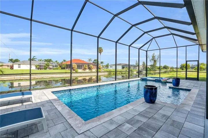 View of swimming pool featuring glass enclosure and a patio area