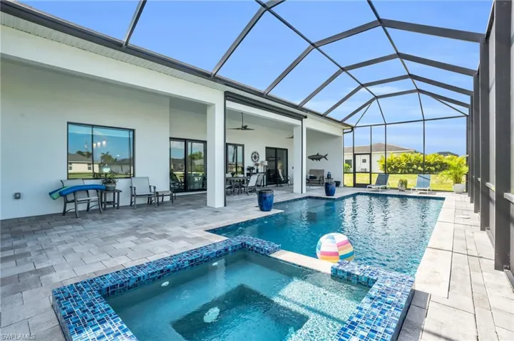 View of swimming pool featuring a patio, a lanai, an in ground hot tub, and ceiling fan