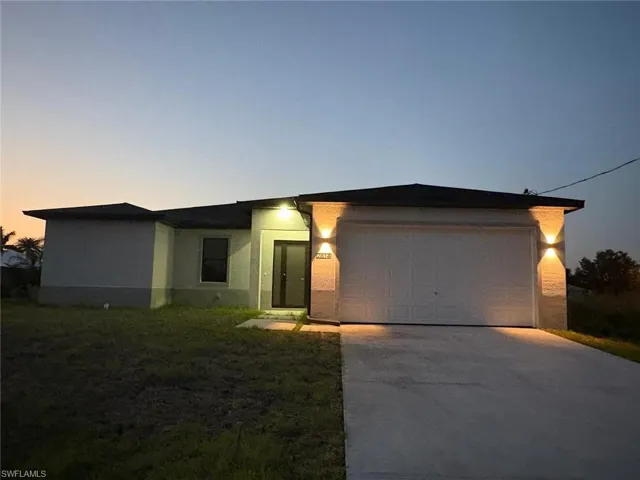 Single-story stucco exterior featuring a two-car garage with a concrete driveway
