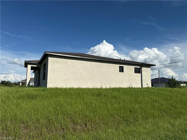 Contemporary stucco exterior with a dark shingle roof and contrasting dark trim