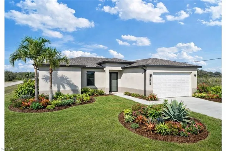 Contemporary stucco exterior featuring a dark asphalt shingle roof, integrated single-car garage, and a lush, landscaped front yard with mature palms and varied plantings