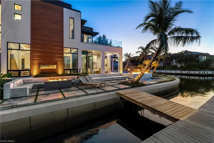 Pool at dusk featuring an outdoor fire pit and a patio area