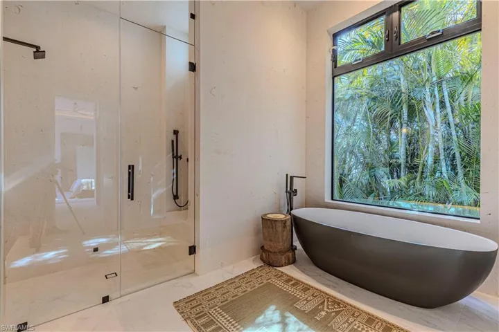 Waster bath with steam shower, oversized tub, full travertine stone wraped wall and window
