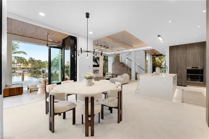 Dining space featuring oversized restoration hardware marble tabl that seats 8 comfortably with speakers above for the perfect dinner party