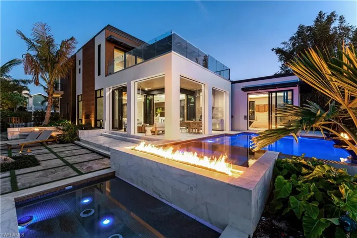 Pool at dusk featuring an outdoor fire pit and a patio area