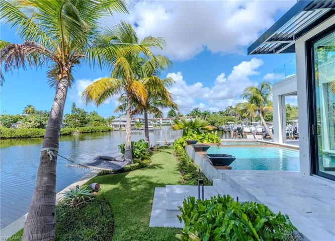 Swimming pool featuring a water view, a yard, and a patio area