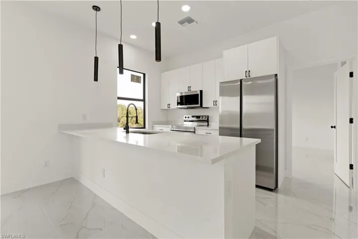 Kitchen featuring visible vents, a sink, marble finish floor, stainless steel appliances, and recessed lighting