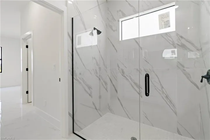 Bathroom with marble finish floor and a marble finish shower