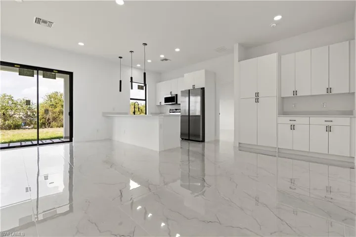Kitchen featuring a wealth of natural light, stainless steel appliances, marble finish floor, and visible vents