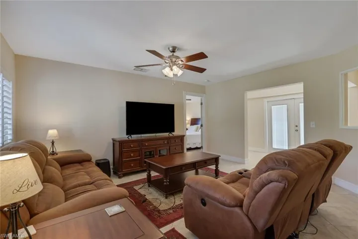 Living area featuring plenty of natural light, a ceiling fan, and light tile patterned flooring