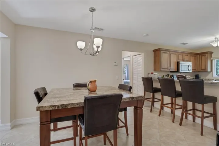 Dining space featuring suspended lighting and light tile patterned flooring