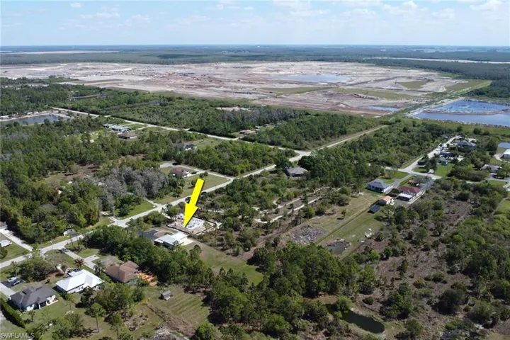 Aerial view of property and surrounding area with a nearby body of water