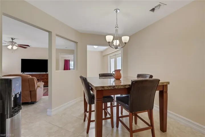 Dining area featuring suspended lighting, ceiling fan, and light tile patterned floors