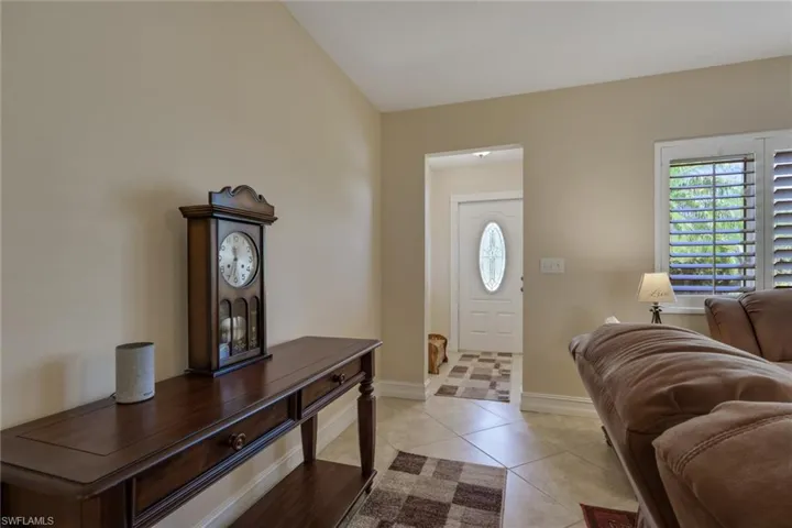 Foyer featuring plenty of natural light, light tile patterned floors, and lofted ceiling