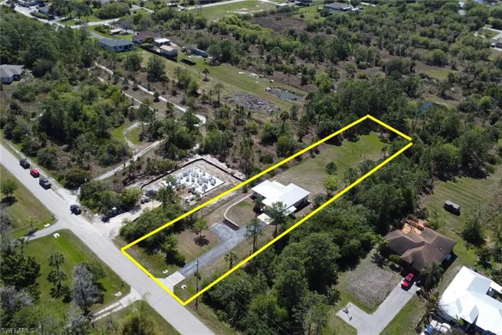 Aerial view of property and surrounding area featuring property boundaries highlighted