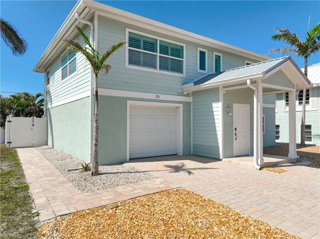 View of residence with a garage and privacy fence