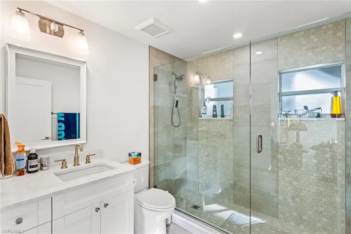 Full bath with vanity, a stall shower, and recessed lighting