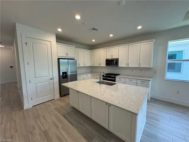 Beautiful, full kitchen layout with quartz countertops, soft-close cabinetry and Whirlpool stainless steel appliances