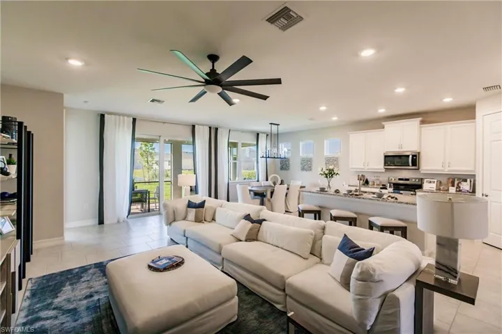 Living room featuring light tile patterned floors and ceiling fan