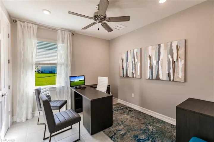 Tiled home office featuring ceiling fan