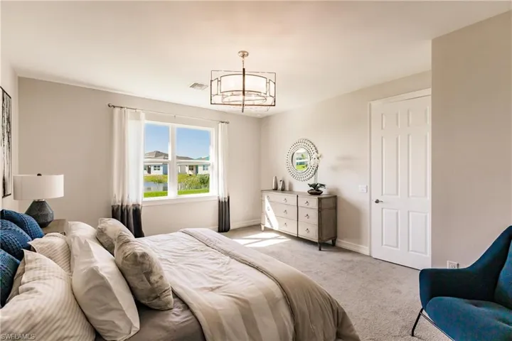 Bedroom featuring an inviting chandelier and light carpet