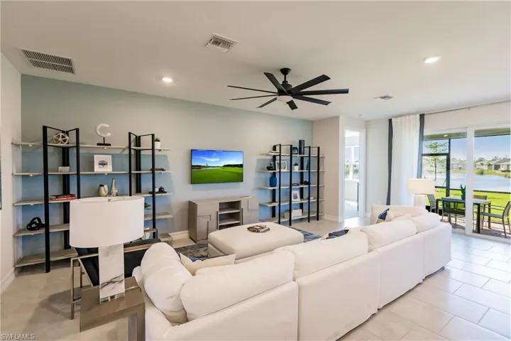 Living room with light tile patterned flooring and ceiling fan
