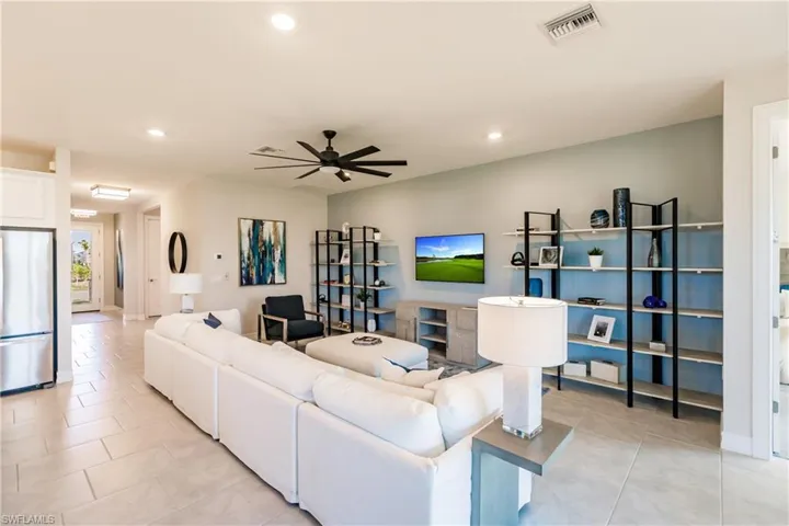 Living room with ceiling fan and light tile patterned floors