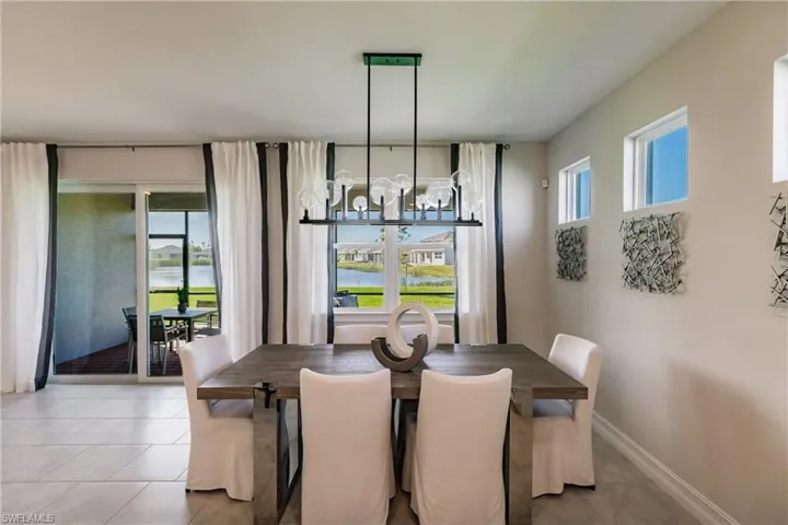 Tiled dining space with a notable chandelier and plenty of natural light