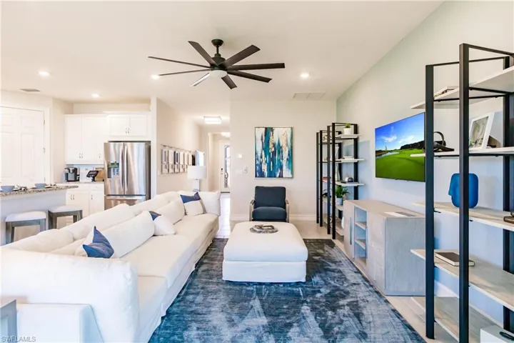Living room featuring dark wood-type flooring and ceiling fan