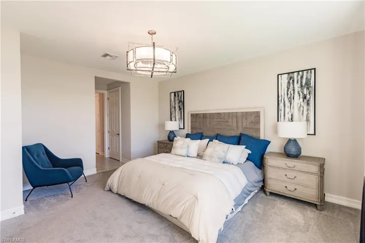Carpeted bedroom with a notable chandelier