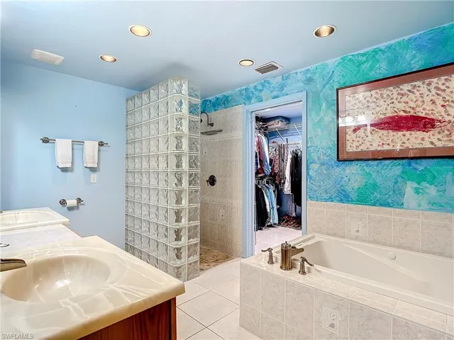 Bathroom with shower with separate bathtub, double vanity, and tile patterned floors