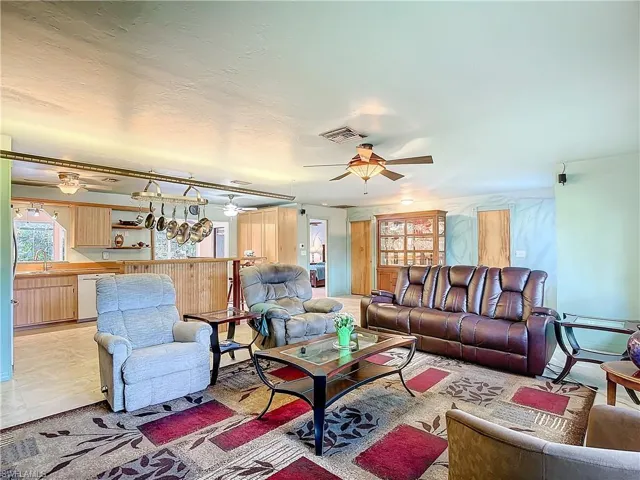 Living room with sink, ceiling fan, and light tile patterned floors